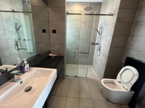 a bathroom with a shower and a toilet and a sink at Opus Residences Warisan PNB 118 View in Kuala Lumpur