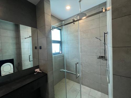 baño con ducha y puerta de cristal en Opus Residences Warisan PNB 118 View, en Kuala Lumpur