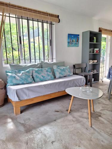 un salon avec un canapé et une table dans l'établissement Maison Tamarin - Riviere Noire pour 5 personnes, à Rivière Noire