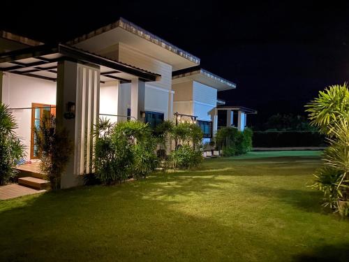 a house with a lawn in front of it at night at KhaoLak Chill Out in Khao Lak