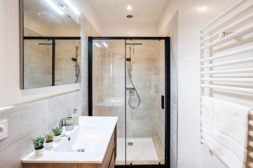 La salle de bains est pourvue d'une douche et d'un lavabo blanc. dans l'établissement Belle Étoile et son Garage privé, à Albertville