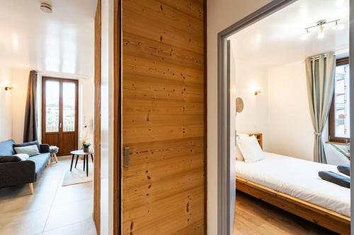 Cette chambre comprend un lit et un mur en bois. dans l'établissement Belle Étoile et son Garage privé, à Albertville