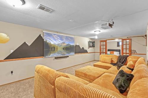 a living room with a couch and two chairs at ᨒFIREHAUSᨒHotTubᨒCinemaᨒBBQᨒBadmintonᨒGames in Arvada