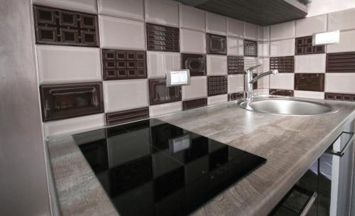 a bathroom with a sink and black and white tiles at Apartments Belgrade in Belgrade