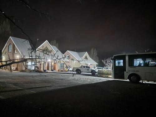 a bus parked in front of houses at night at Eldorado Lodge CC in Kuruman