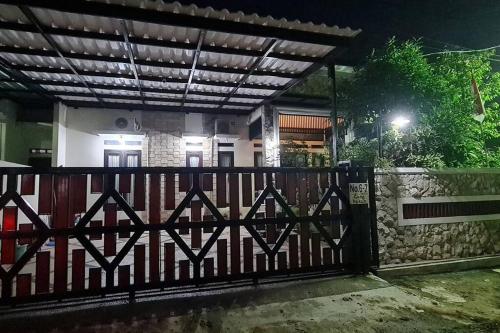 a gate in front of a house at night at Shazia House - Modern and Cozy Home with 3 Bedrooms and Private Pool in Tanjungkarang