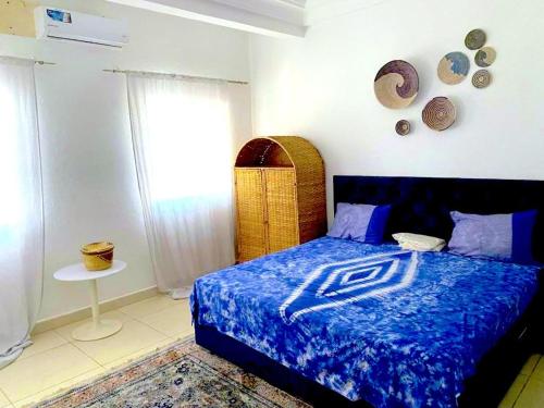 a bedroom with a bed with a blue comforter at HomeVilla in Tranquil