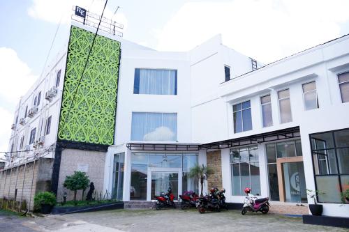 a white building with motorcycles parked in front of it at Urbanview Hotel Ratu Elok Syariah Banjarbaru by RedDoorz in Martapura