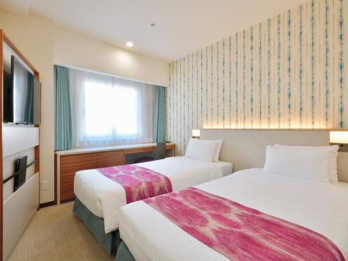Katil atau katil-katil dalam bilik di Hotel JAL City Naha