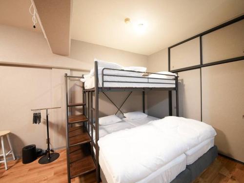 a bedroom with two bunk beds in a room at TasoneUrbanStayOsaka なんば日本橋南不夜城704 in Osaka