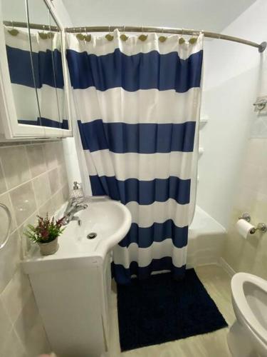 a bathroom with a sink and a shower curtain at Prime Location Duo Nest & Rest in Kingston