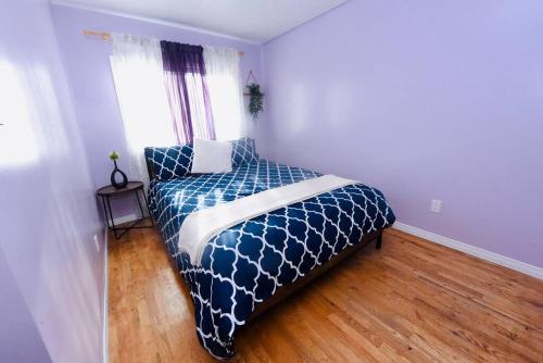 1 dormitorio con 1 cama con edredón azul y ventana en Spacious perfect 2BR in prime location en Kingston