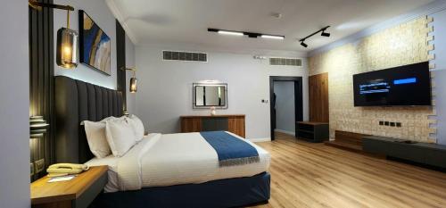 a hotel room with a bed and a flat screen tv at Qasr Al Sahab in Khamis Mushayt