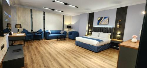 a hotel room with a bed and a blue couch at Qasr Al Sahab in Khamis Mushayt