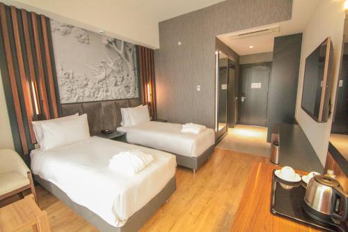 um quarto de hotel com duas camas e uma televisão em S CLASS HOTEL CONVENTION CENTER em Güllüce