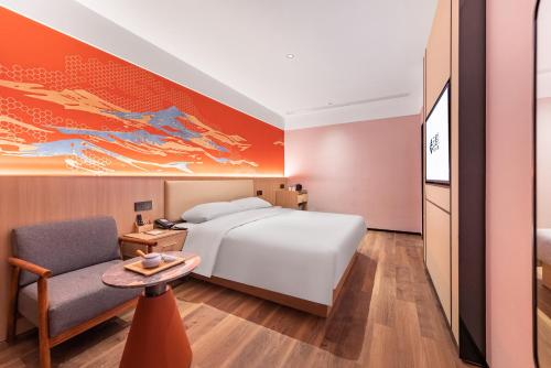 Habitación de hotel con cama y silla en Yunju Hotel Beijing Yonghe Palace Guijie Siheyuan, en Beijing