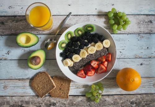 a table with a bowl of fruit and a plate of bread at Tripsea Beach Villa in Alleppey