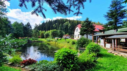a house and a river next to a building at Penzion U rybníka in Šumperk
