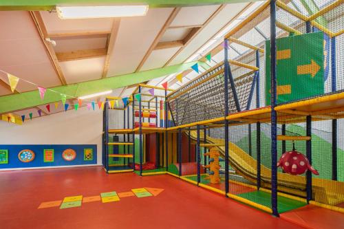 an indoor play room with a slide and a playground at Summio Buitenplaats De Hildenberg in Appelscha