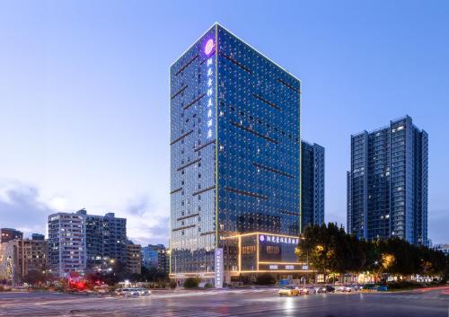 um edifício alto numa cidade à noite em Grand Mercure Jinan Sunshine em Jinan