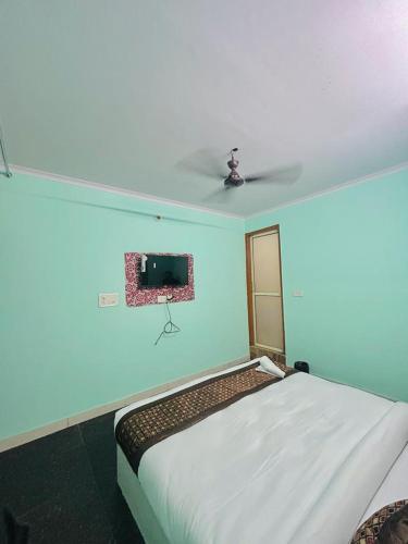 a bedroom with a bed with a tv on the wall at drem with agniv in New Delhi