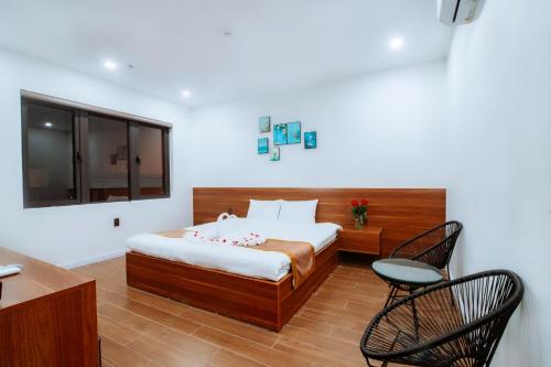 um quarto com uma cama, uma mesa e cadeiras em Diamond Hotel Quảng Bình em Dong Hoi