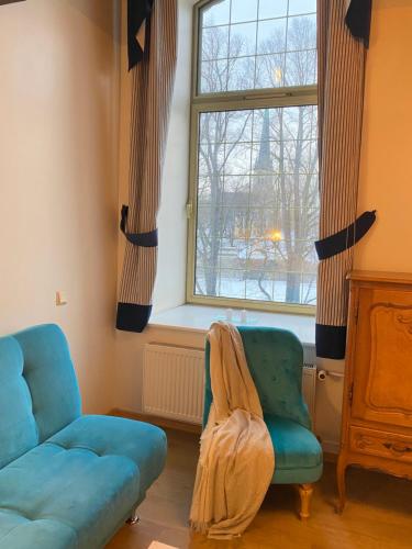 sala de estar con sofá, silla y ventana en Loft Ilmarine en Tallin