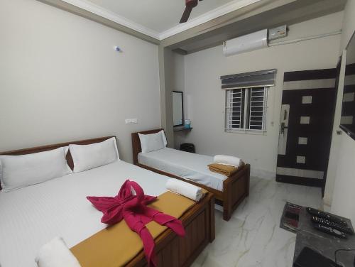 a bedroom with two beds with a bow on them at Sri Aksha Residency in Alāndurai