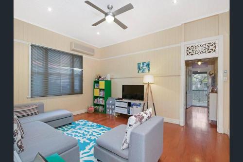 a living room with a couch and a ceiling fan at Beautiful house with city views in Brisbane