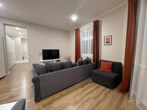 een woonkamer met een bank en een televisie bij New apartment 1 - self check in, free parking in Bratislava
