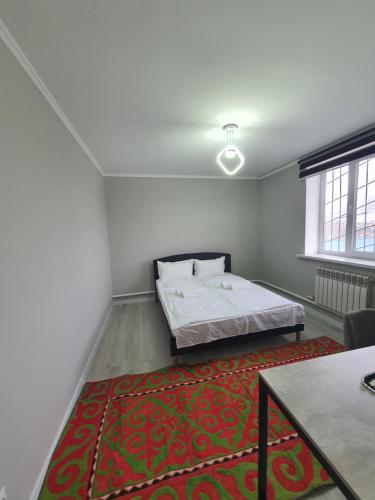 una camera con un letto e un tappeto rosso di Terrabella a Bishkek