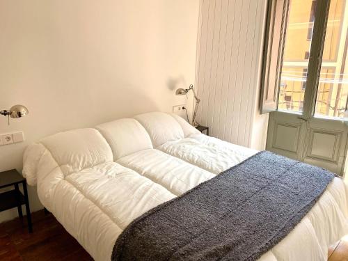 Sofá blanco en una habitación con ventana en l'Apartament de la Plaça, en Puigcerdà