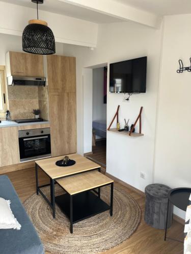 un salon avec une table basse et une cuisine dans l'établissement Le petit gîte de la Gare, à Mussidan