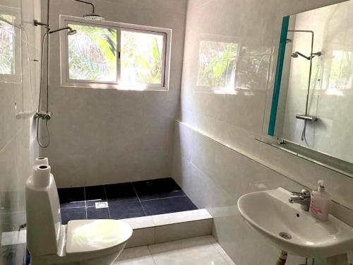 a bathroom with a sink and a toilet and a mirror at HomeVilla in Tranquil