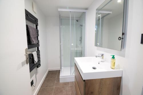 a white bathroom with a sink and a shower at Vacances au Bonhomme in Le Bonhomme