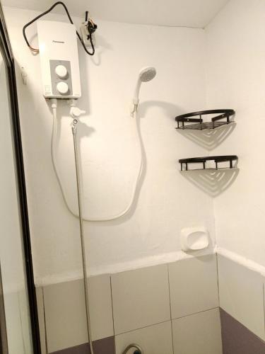 a shower with a shower head in a bathroom at Elisha's Guest House in Coron