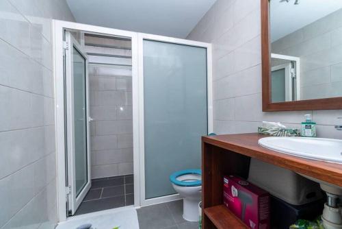 y baño con ducha, lavabo y aseo. en HEITEA LODGE - 6 min airport, Wifi, AC & Parking, en Papeete