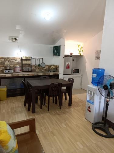 a kitchen and dining room with a table and chairs at Elisha's Guest House in Coron