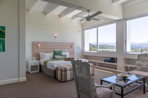 1 dormitorio con 1 cama y 1 sofá en Lookout Lodge, en Plettenberg Bay