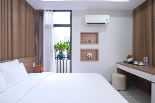 Un dormitorio con una gran cama blanca y una ventana en Mother's Home, en Ho Chi Minh
