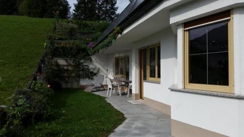 uma vista lateral para uma casa branca com um pátio em Haus am Waldrand em Thiersee