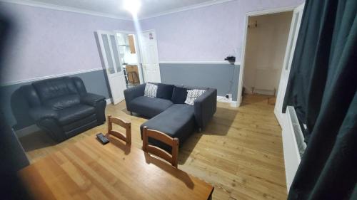 ein Wohnzimmer mit einem Sofa und einem Stuhl in der Unterkunft Cosy And Relaxing in Chatham