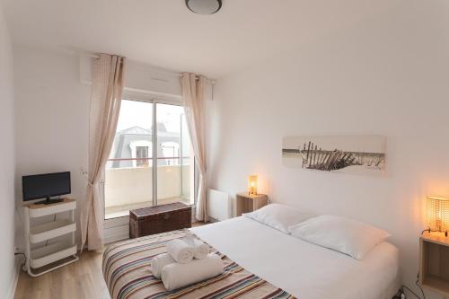 une chambre blanche avec un lit et une fenêtre dans l'établissement Amatasi - Appt Duplex vue mer, à Saint-Malo
