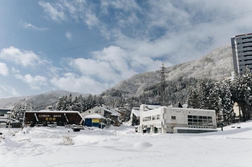 HOTEL JUSTICE Ski IN-Ski OUT في Seki: مدينة في الثلج وجبال في الخلفية
