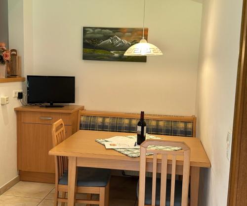 a dining room table with a bottle of wine on it at Haus Ausserbach in Gaschurn