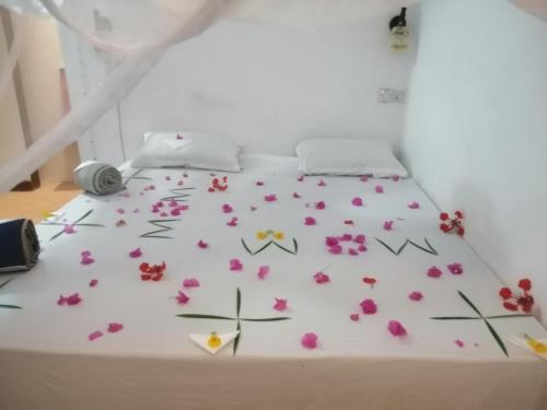 a bed with flowers on it in a room at Wow Beach House in Jambiani