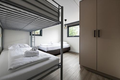 a bedroom with two bunk beds and a window at 20, Nestled in the woods, Big Chalet and Garden! in Oisterwijk