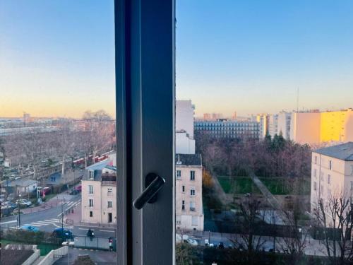 a window with a view of a city at Booking in Clichy