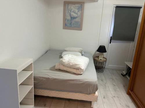 - une petite chambre avec un lit et une commode dans l'établissement Als garden, à Goussainville