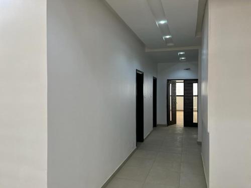 a hallway of a building with white walls and white floors at Keeluxe Cite Keur Gorgui- Superbe appartement in Dakar